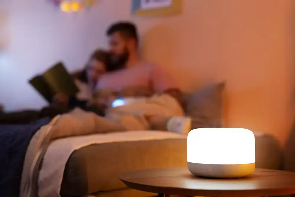 ljuskälla hemma. med två personer i bakgrunden som myser och läser en bok